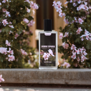 A Perfume named "Jasmine Euphoria" is placed on a Concrete Wall with the background of Trees